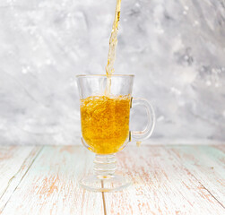 Pouring black tea into a glass