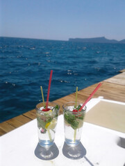 Fresh fruit cocktails on the backgrounf of the blue sea, tropical vacation