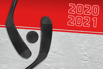 A fragment of a hockey rink, two hockey sticks and a puck