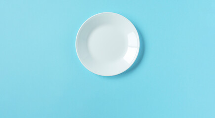 White plate on light blue background. 水色背景上の白いお皿
