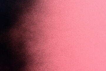 black spray paint on a pink colored paper background