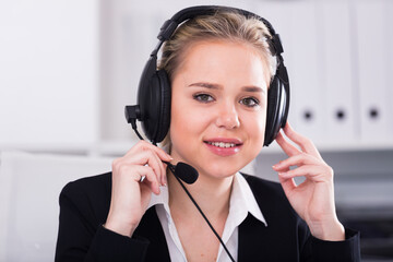 Portrait of smiling female customer support phone operator at workplace