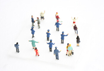 Top view group of miniature people in different colors costume, generation and career stand on white background. Concept communication of society and social distancing. selective focus.