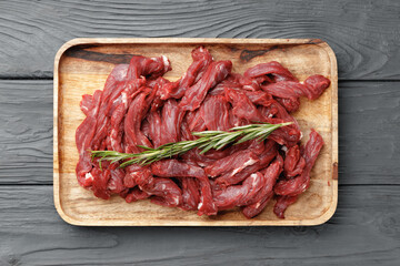 Raw sliced beef meat on wooden board