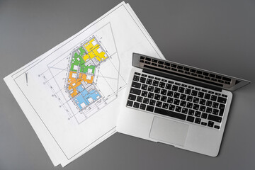 Working table of interior designer with blueprint and laptop