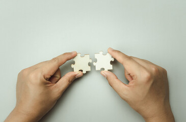 Top view of hand businessman  holding blank puzzle jigsaw pieces. Teamwork success and strategy concept, cooperation business solutions think or new idea, Security help support management, copy space.