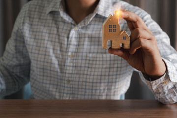 Hand businessman holding model house wooden. Insurance of Property house. Security and Real estate business finance. Financial of sell buy and loan of mortgage crisis, building construction concept.