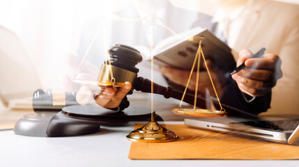 Business and lawyers discussing contract papers with brass scale on desk in office. Law, legal services, advice, justice and law concept picture with film grain effect