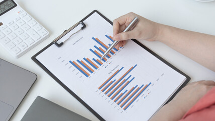 Asian women are analyzing graphs, market data and assessing investment risks, Working at home...