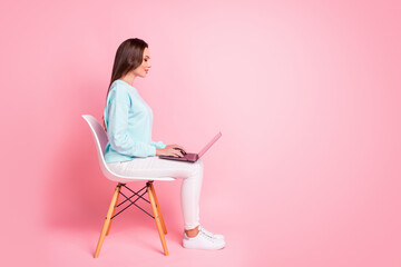 Full body profile photo of positive lady look screen typing message light blue pullover isolated on pink color background