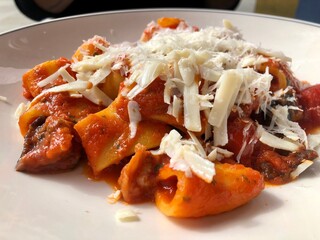 Large italian pasta served with tomato sauce and grated cheese