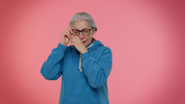 Disappointed upset elderly old granny gray-haired woman wipes tears and cries from despair, being sad because of unfair situation. People lifestyle emotions. Senior grandmother pensioner studio shot