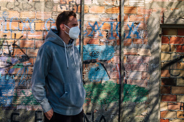 man with medical mask on public wall with graffiti not subject to copyright