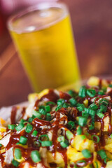 Papas fritas con barbacoa, bondiola y un vaso de cerveza