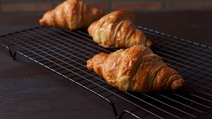 croissant recién horneados enfiandose en una rejilla metálica