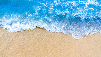 Fototapeta na wymiar Wave of blue ocean on sandy beach background
