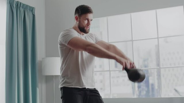 Muscular guy exercises dumbbell snatch with cast iron weight