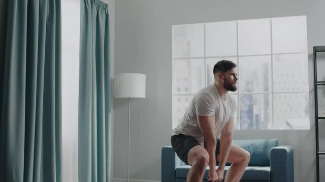 Professional bearded bodybuilder exercises dumbbell snatch