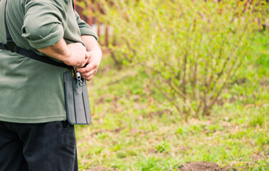 farmer working with grass-cutter on spring farmland soil