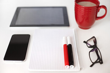 Top view of office work place in white, black and red colors
