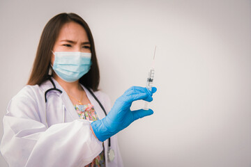 A young nurse holding a syringe in a hospital ward, Concept fight against virus covid-19 corona virus, Concept:diseases,medical care,science.