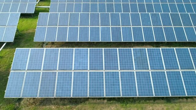Aerial view of Solar Panels Farm Solar Cell Station. Production of clean energy. Renewable green alternative energy concept. Camera moves left