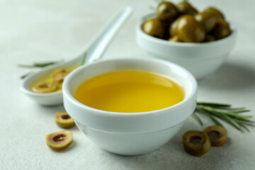 Bowls with olives and oil on white textured background