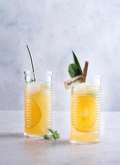 Ginger Ale, Pineapple and orange mocktail on stone concrete background. Selective focus, copy space.