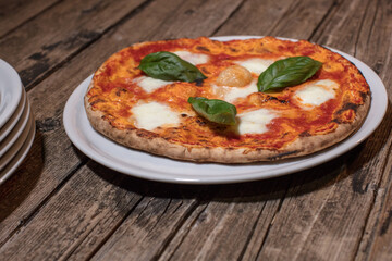 Pizza Margherita on dark rustic wood background.