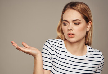 indignant blonde on beige background in striped t-shirt model cropped view