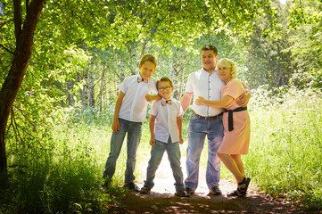 Fun walk of large family in the summer forest. Mother, father, brothers walking in the park or forest on a sunny day