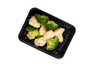 Container with cooked broccoli and cauliflower. Food delivery. Lunch box with food ready to go. Top view. Isolated