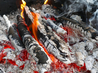 Almost extinguished fire left over from cooking on the fire. Summer day. Embers are visible