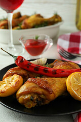 Concept of delicious eating with roast chicken drumsticks on white textured table