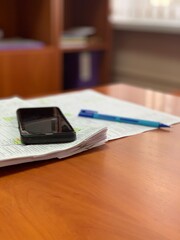 A calculator and a pen lie on the table in the office.