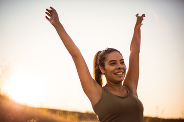 African woman standing in the nature and outstretched arms.