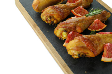 Board with roast chicken drumsticks isolated on white background