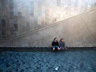 Two Asian brothers relax at swimming pool with love