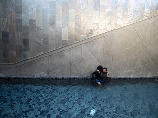 Two Asian brothers relax at swimming pool with love