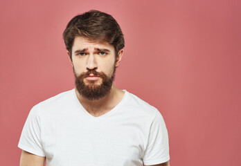 Fototapeta premium A man in a white T-shirt with a beard on a pink background Copy Space