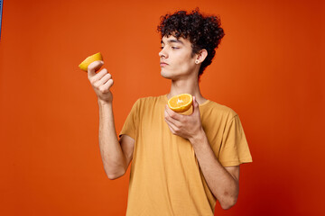 Fototapeta premium guy with curly hair and holding an orange isolated background