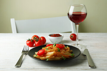 Concept of tasty food with pasta with tomato sauce on white wooden table
