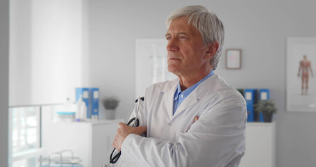 Portrait of mature male doctor standing in the hospital office.