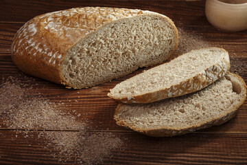Sliced rye bread with flour on a wooden background