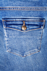 Blue jeans pocket with flap and brass metal button close up, jeans pocket background, blue denim...