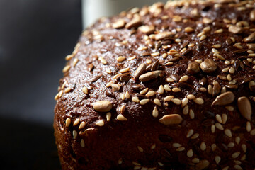 food, baking and cooking concept - homemade craft bread with sesame and sunflower seeds on table