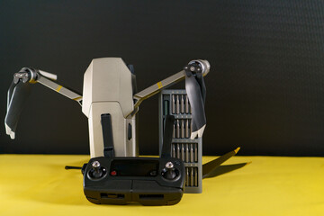drone with screwdriver repair kit on yellow black background