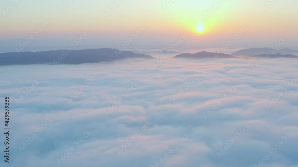 Wall mural Aerial view flying in the clouds at sunset. Gold colored sunset cloudiness in high contrast. Real sky. The concept of dreams and weather forecast. Los Angeles during sunrise in beautiful summer day.