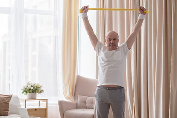 Senior man training at home exercising at home with an elastic band