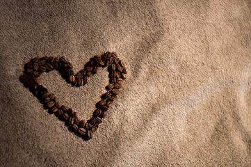heart arranged from delicious black coffee on a soft background in the side of the photo